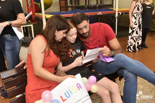Família lendo mensagem afetiva em comemoração escolar do OMNI