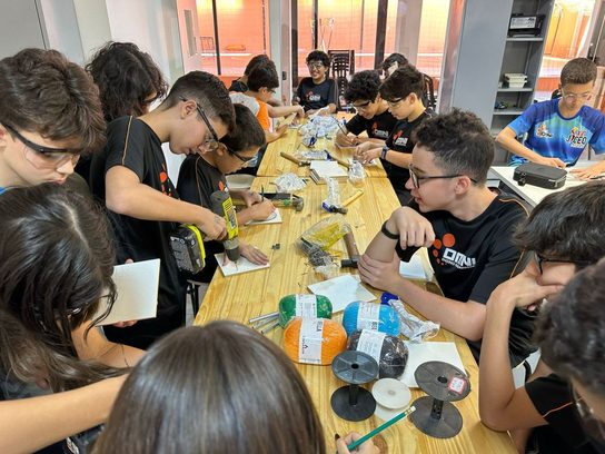 Alunos do OMNI no Espaço Maker montando projeto com furadeira e materiais de marcenaria