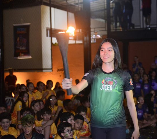 Aluna do OMNI carregando a tocha acesa na abertura do JICEO